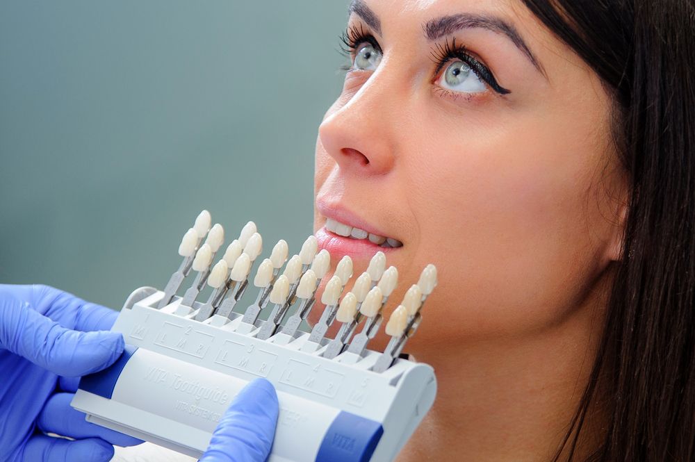 doctor viendo el mejor tono de prótesis dental para paciente
