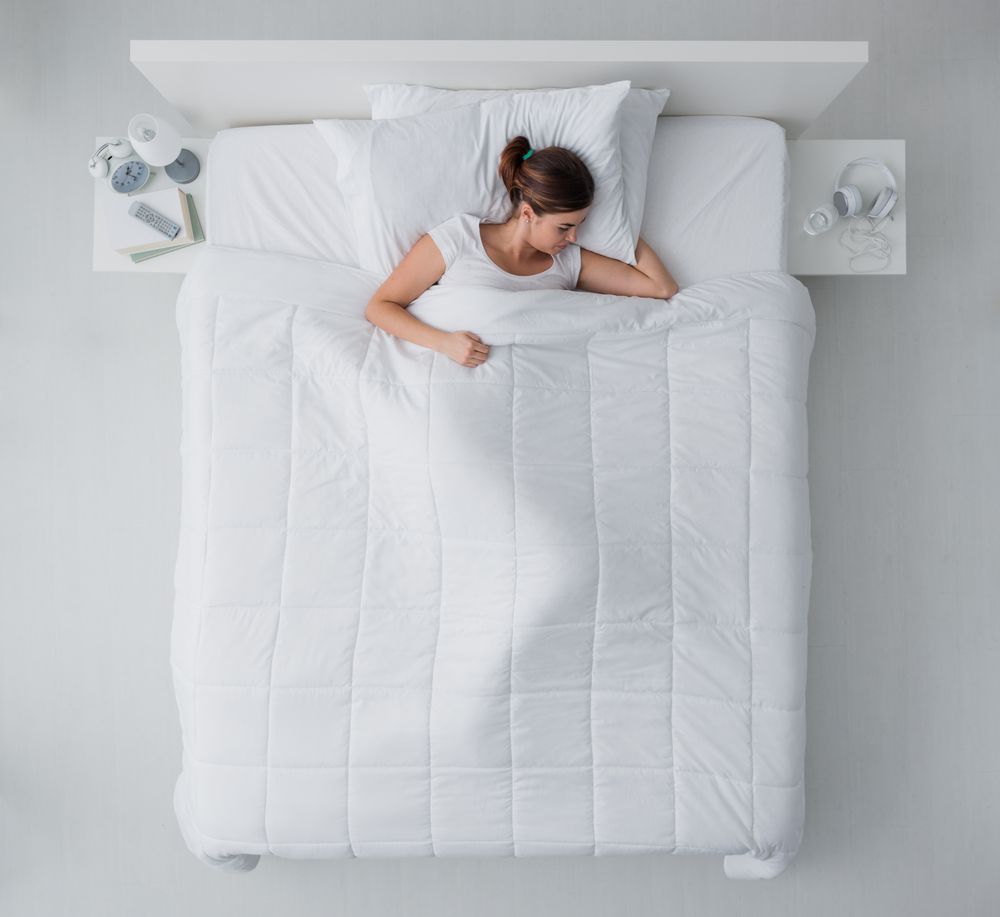 mujer durmiendo en una cama blanca