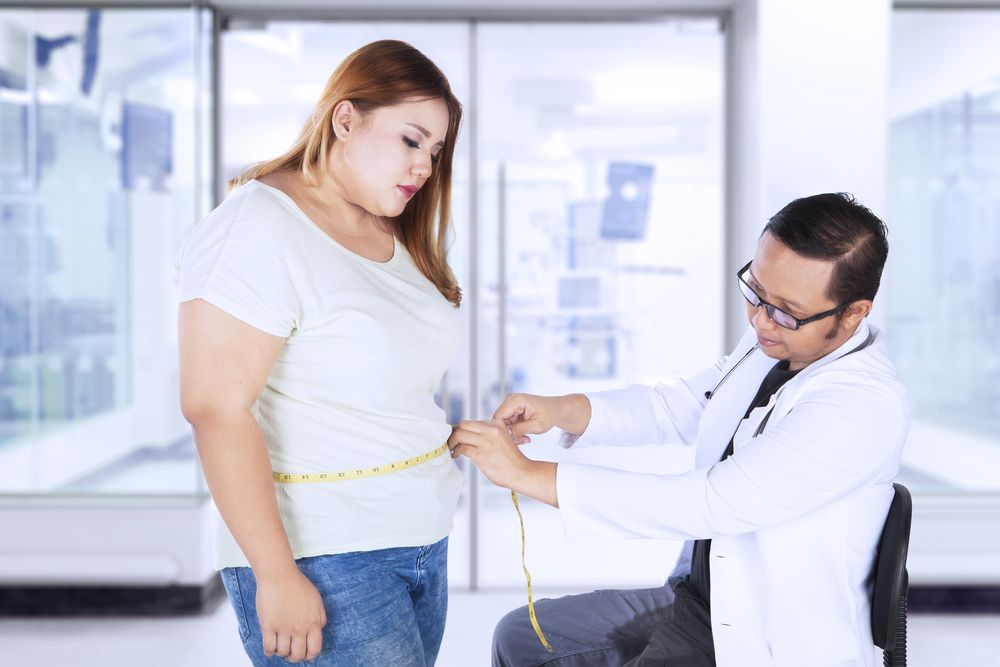 mujer siendo medida por un médico