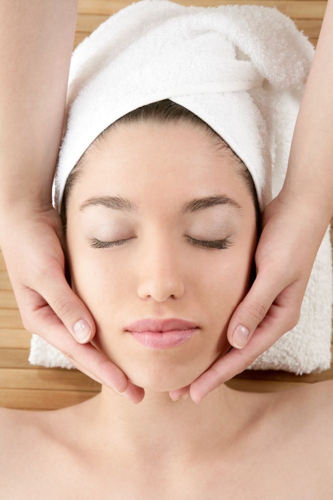 mujer recibe masaje en su rostro