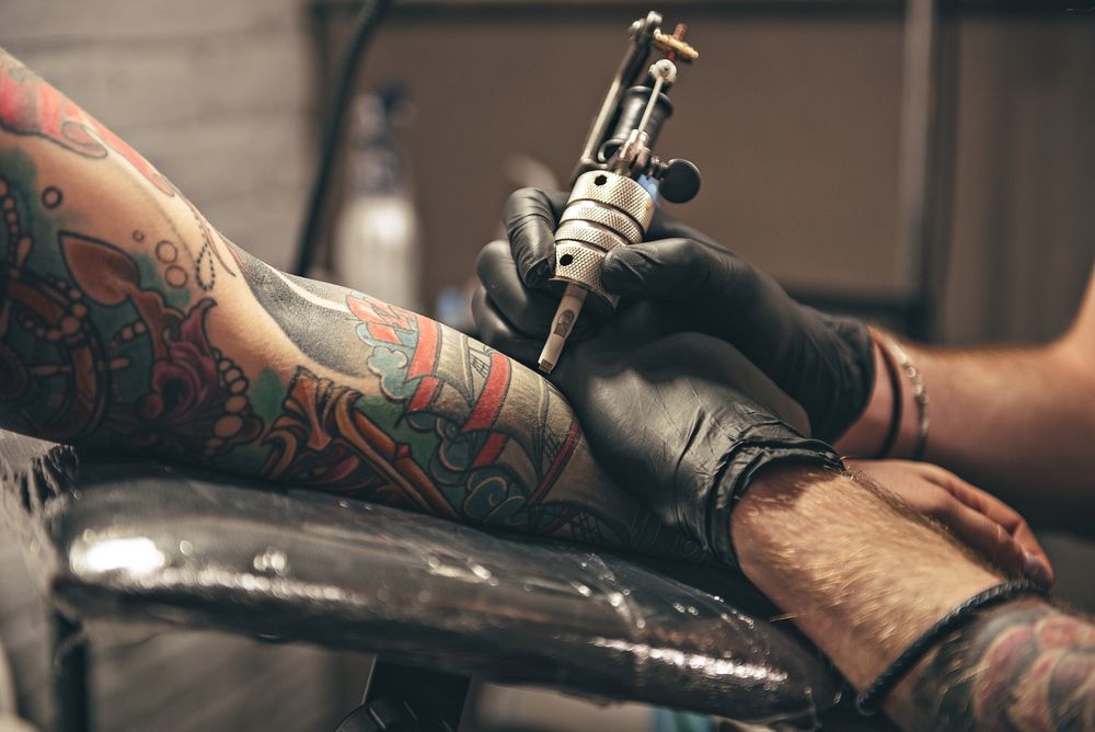 Persona siendo tatuada en el brazo