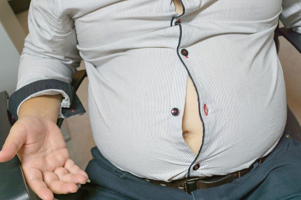 Hombre con sobrepeso vistiendo una camisa ajustada