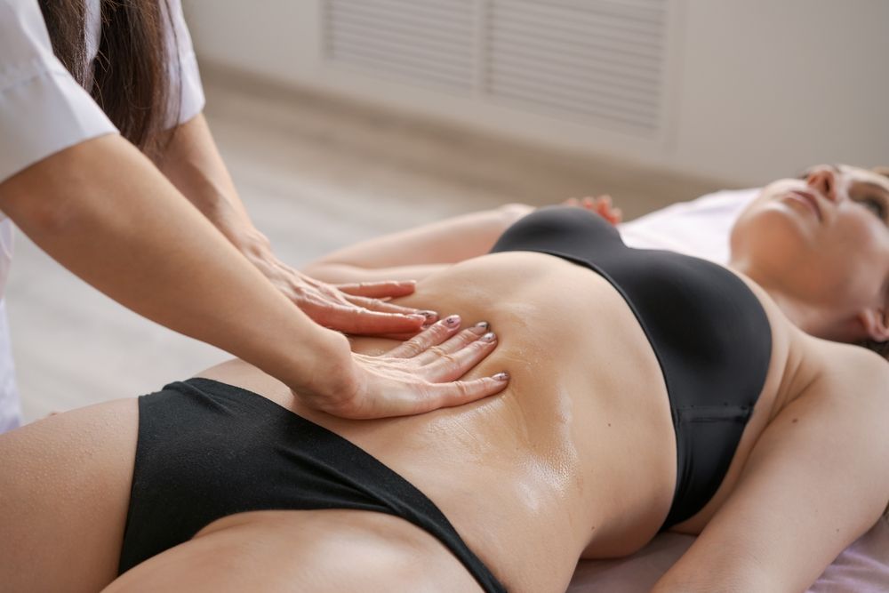 mujer recibiendo masaje en el abdomen
