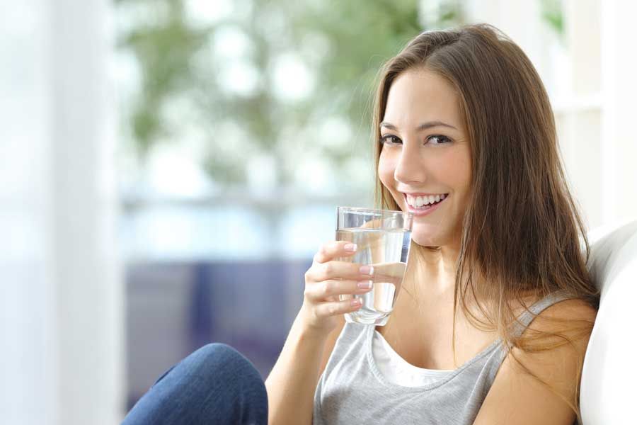 mujer tomando un vaso con agua