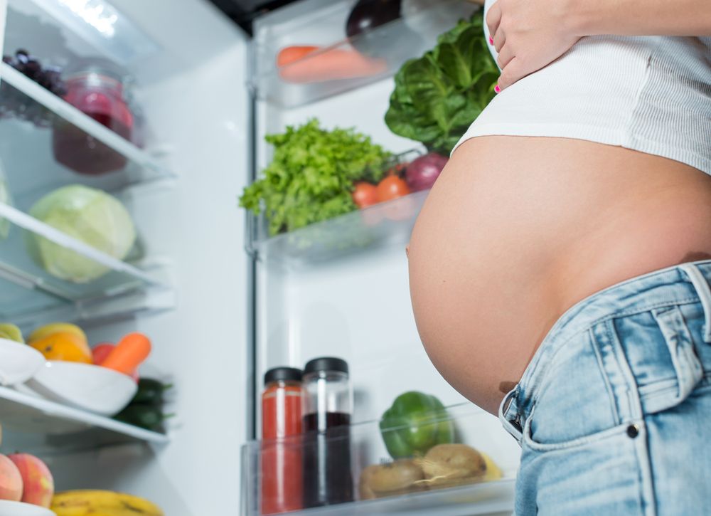 mujer embarazada abriendo el refrigerador