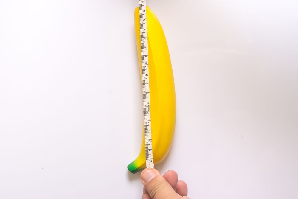 persona midiendo una banana