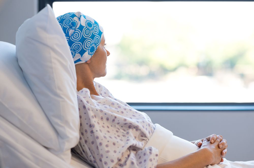 Paciente con cáncer mirando por la ventana de un hospital