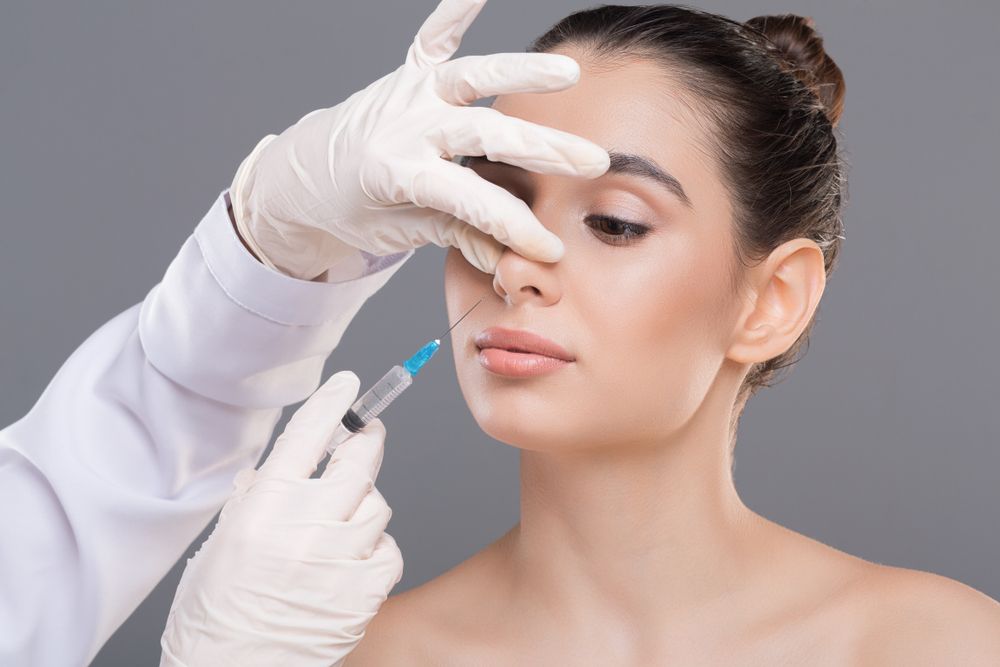 Mujer recibe inyección de relleno facial en la nariz