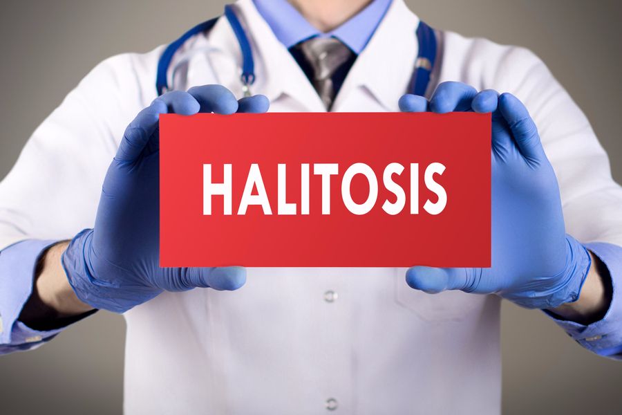 médico soteniendo un cartel que dice halitosis