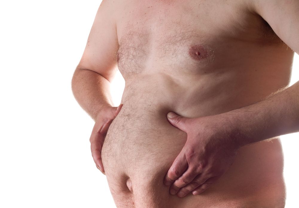 hombre tocandose la grasa del abdomen