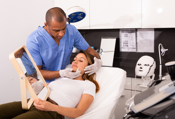 Doctor examina el rostro de una paciente antes de su tratamiento